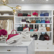 Bag-a-Vie natural herringbone canvas dustbags protecting luxury handbags on a marble closet island