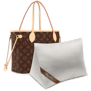 Bag-a-Vie white herringbone purse shaper pillow next to a brown monogram tote bag for shape preservation